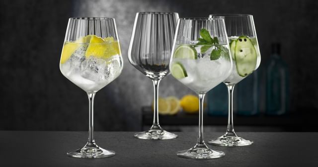 Four NACHTMANN Gin and Tonic glasses, three of them filled with different gin cocktails, one of them empty.