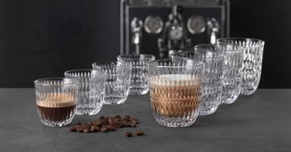 Four NACHTMANN Barista espresso glasses and four latte macchiato glasses, with the front one filled with the coffee specialty