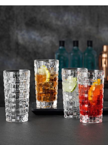 Four NACHTMANN Bossa Nova longdrink glasses, three of them filled with different beverages on ice.<br/>