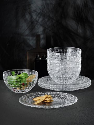 The small NACHTMANN Bossa Nova plate with small slices of bread on it and the Bossa Nova food bowl filled with a salad. In the background are three more plates and bowls stacked up.<br/>